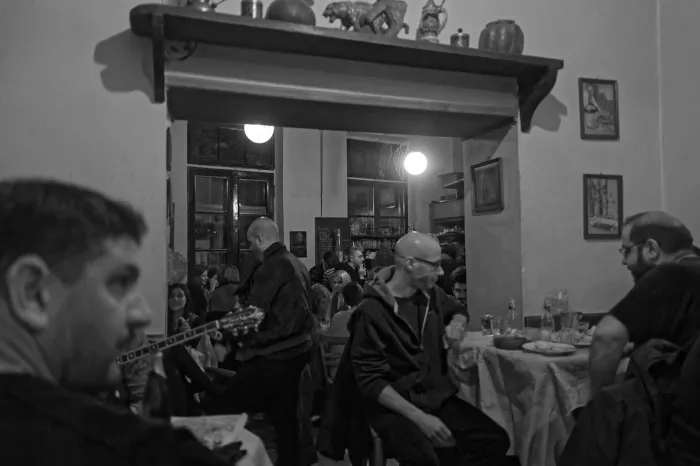 Black and white photo of people sitting at tables at a cafe