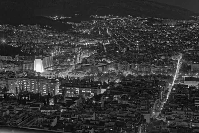 Black and white city skyline at night illuminated by lights