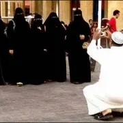 Man taking a photo of a group of women wearing niqabs