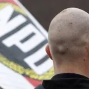 A man with a bald head holding a flag