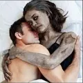 a man hugging a female zombie in bed