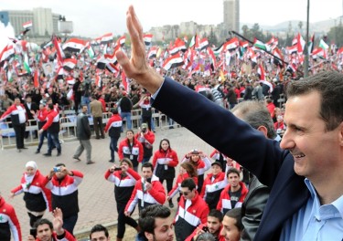 Hafez al-Assad waving at a crowd of people