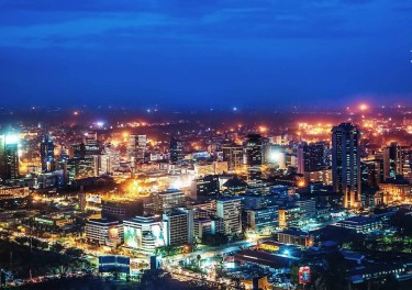 A city skyline at night with building lit up by lights