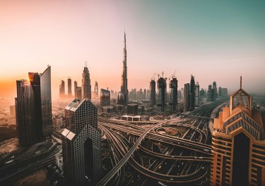 aerial photo of city highway surrounded by high-rise buildings. Sunrise shot of Downtown Dubai and Burj Khalifa.