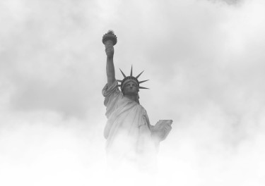 grayscale photo of statue of liberty surrounded by fog