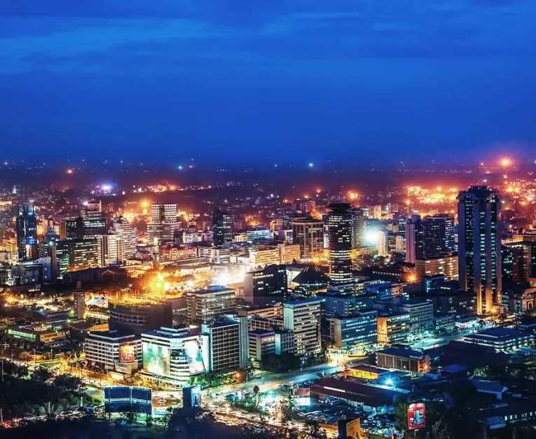 A city skyline at night with building lit up by lights